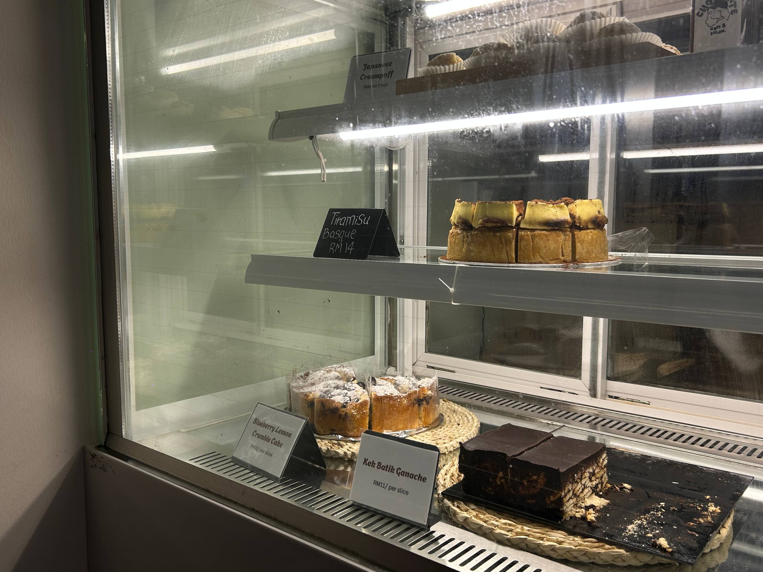 Cakes and desserts displayed in the Kopi & Bulan counter