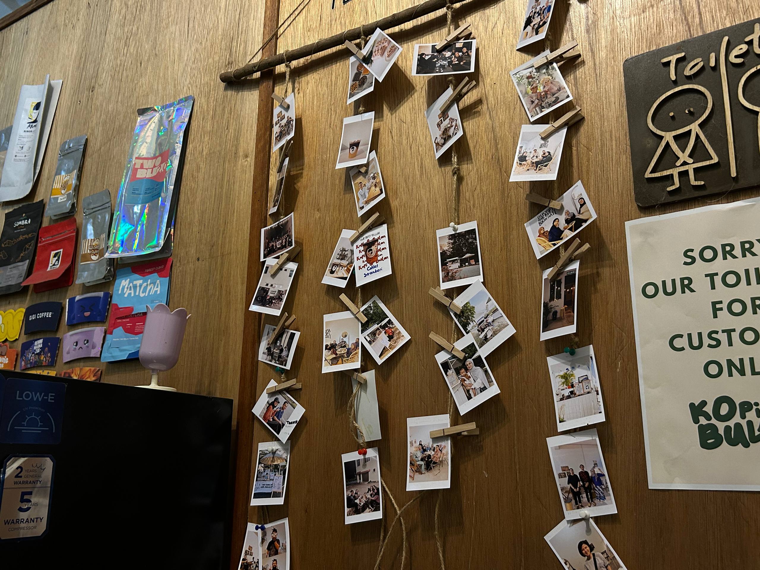 Customer photographs clipped to strings on the café memory wall
