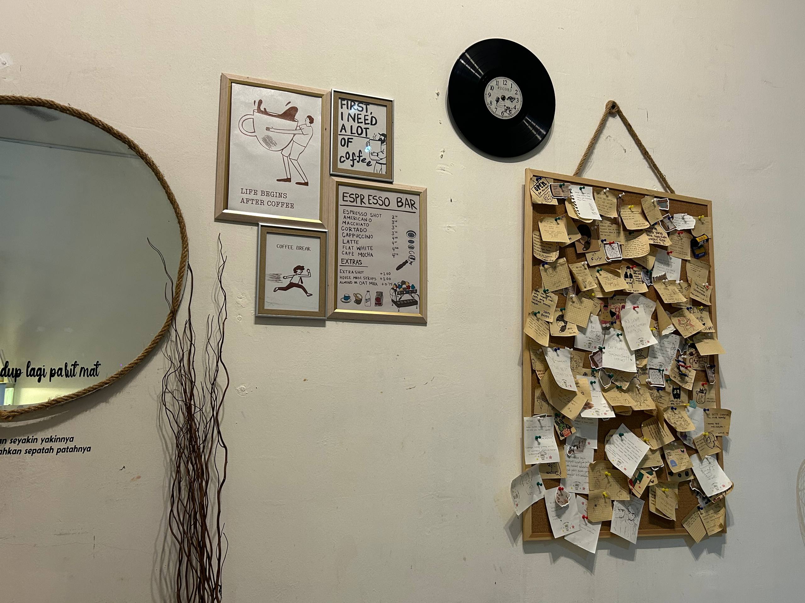 Customer notes, framed coffee prints and a record clock on the café wall